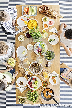 Group of kids eating healthy dinner with vegetables Stock Photo