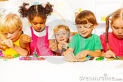 Group of kids in kindergarten play with plasticine Stock Photo