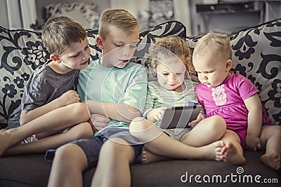 Group of kids playing with an electronic tablet devices Stock Photo