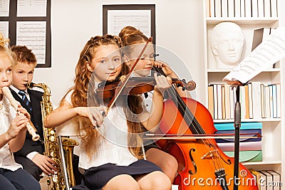 Group of kids playing musical instruments indoors Stock Photo