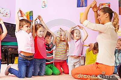 Group of kids repeat gesture after the teacher Stock Photo