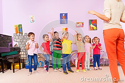 Group of kids repeating exercise after teacher Stock Photo