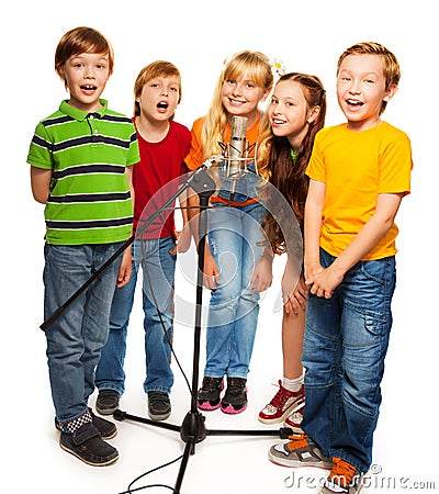 Group of kids singing to microphone Stock Photo