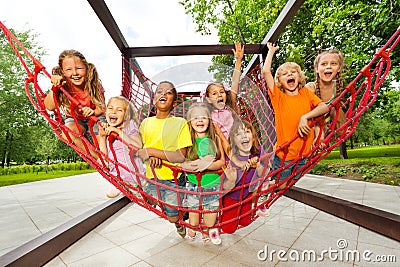 Group of kids sitting on playground net ropes Stock Photo