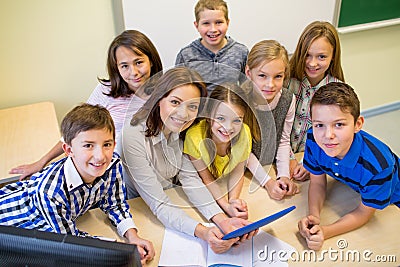 Group of kids with teacher and tablet pc at school Stock Photo