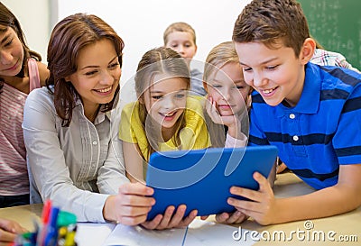 Group of kids with teacher and tablet pc at school Stock Photo