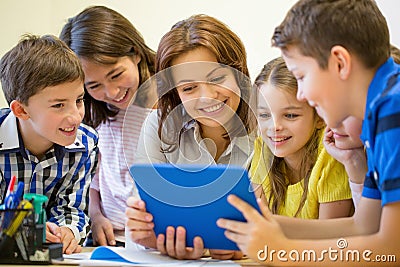 Group of kids with teacher and tablet pc at school Stock Photo