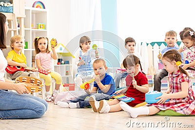 Group of kindergarten children play with musical toys. Early musical education in daycare Stock Photo