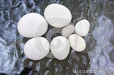 Group of light white massage pebbles on glass background, reflections Stock Photo