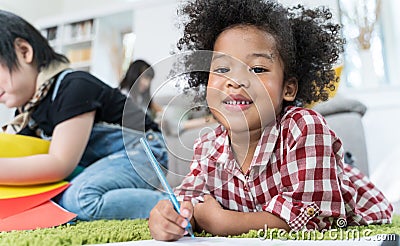 Group of little preschool kids drawing paper with color pencils . portrait of African girl with friends education concept. Stock Photo