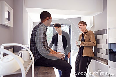 Group Of Male College Students In Shared House With Hot Drinks In Kitchen Hanging Out Together Stock Photo