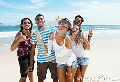 Group of male and female young adults dancing at beach Stock Photo