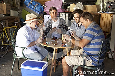 Group Of Male Friends Playing Cards In Garage Stock Photo