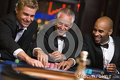 Group of male friends at roulette table Stock Photo