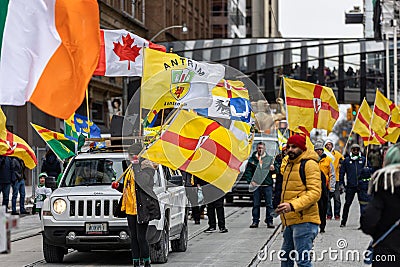 A group marching with County Antrim flags at the Saint Patrick's Day parade on Queen Street Editorial Stock Photo