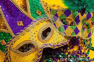 Group of Mardi Gras Masks on yellow Background wtih beads Stock Photo