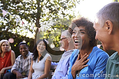 Group Of Mature Friends Socializing In Backyard Together Stock Photo