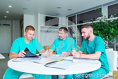 Group of medical staff discussing patient results in clinic. Healthcare professionals having discussion in hospital. Experienced Stock Photo