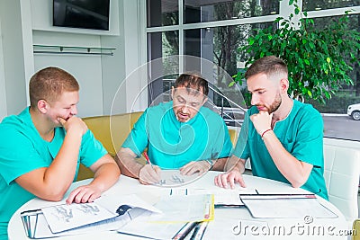 Group of medical staff discussing patient results in clinic. Healthcare professionals having discussion in hospital. Experienced Stock Photo