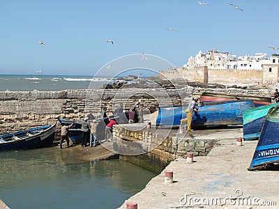 A group of men haul a boat in the fishing port of Essaouira, Morocco Editorial Stock Photo