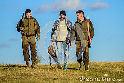 Group men hunters or gamekeepers nature background blue sky. Guys gathered for hunting. Men carry hunting rifles Stock Photo
