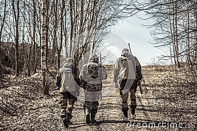 Group of men hunters going up on rural road during hunting season Stock Photo