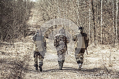 Group of men hunters outgoing on rural road during hunting season Stock Photo