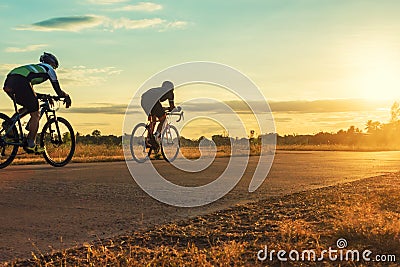 Group of men ride bicycles at sunset with sunbeam Stock Photo