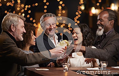 Group Of Middle Aged Friends Celebrating In Bar Together Stock Photo