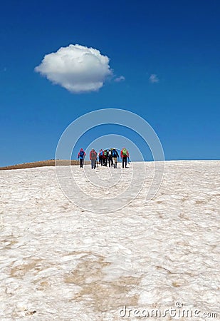 Group of mountain climbers walking on snow with white cloud in sky Stock Photo