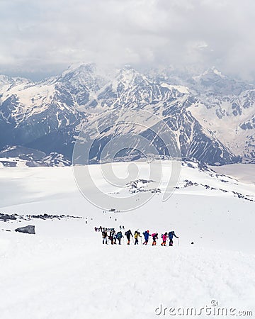 Group of mountaineers climbing in the snowy mountain peaks. Stock Photo