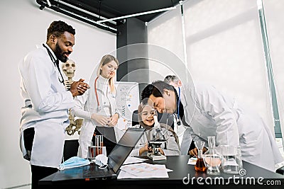 Group of multiethnic scientists feel happy after successful trial scientific experimental test, new discovery, solution Stock Photo
