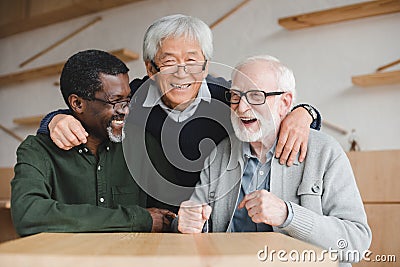 Senior friends embracing in bar Stock Photo