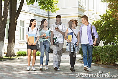 Group of multiethnic students walking together outdoors in college campus Stock Photo