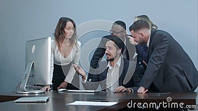 Group of multiracial business people around the conference table looking at laptop computer and talking to one another Stock Photo