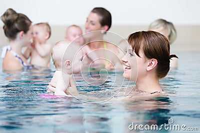 Group of mothers with children at baby swimming lesson Stock Photo