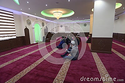 Group of Muslim men kneeling and listening to mullah preaching in a mosque. Kyiv, Ukraine Editorial Stock Photo