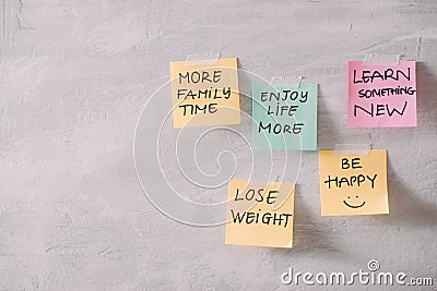 Group of New year Resolution Notes on pink, yellow, orange and green on wall written with message of more family time, lose Stock Photo