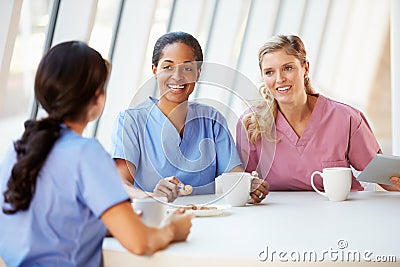 Group Of Nurses Chatting In Modern Hospital Canteen Stock Photo