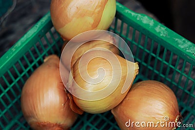 an group onion on green basket on wooden table Stock Photo