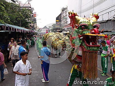 A group of people accompany a large dragon in a Festival of the Clans of the Chinese community of Bangkok Editorial Stock Photo