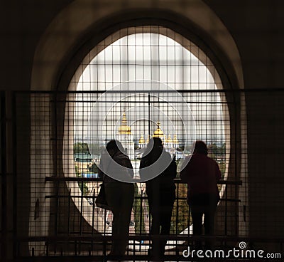 Group of people admiring looking through a fenced window to the St Sophia's cathedral in Kyiv Stock Photo