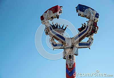 Group of people on a amusement park game spinning in the sky. Having fun on a fairground ride Editorial Stock Photo