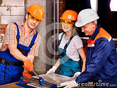 Group people builder cutting ceramic tile. Stock Photo