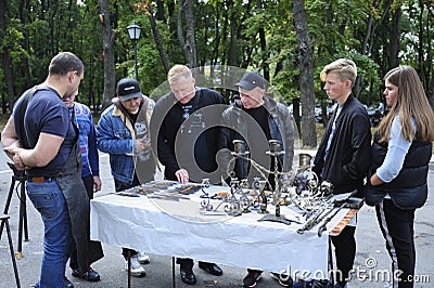 Group of people, buyers, and blacksmith left standing in front of a table with forgings and discussing them Editorial Stock Photo