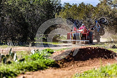 Group of people carrying bicycles on a dusty path in Burnet, United States Editorial Stock Photo