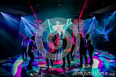 Group of people dancing on a dance floor in dark night club environment Editorial Stock Photo