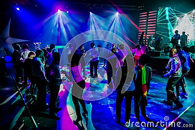 Group of people dancing on a dance floor in dark night club environment Editorial Stock Photo