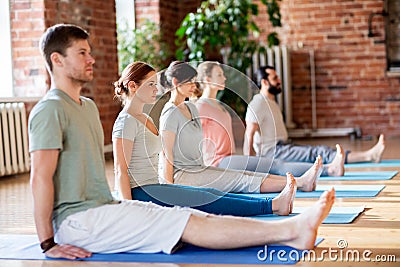 Group of people doing yoga staff pose at studio Stock Photo