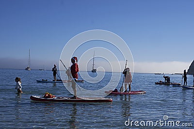 A group of people dressed as santa claus doing paddle in the Poetto beach in Cagliari - Sardinia - ITALY 2022 DECEMBER Editorial Stock Photo